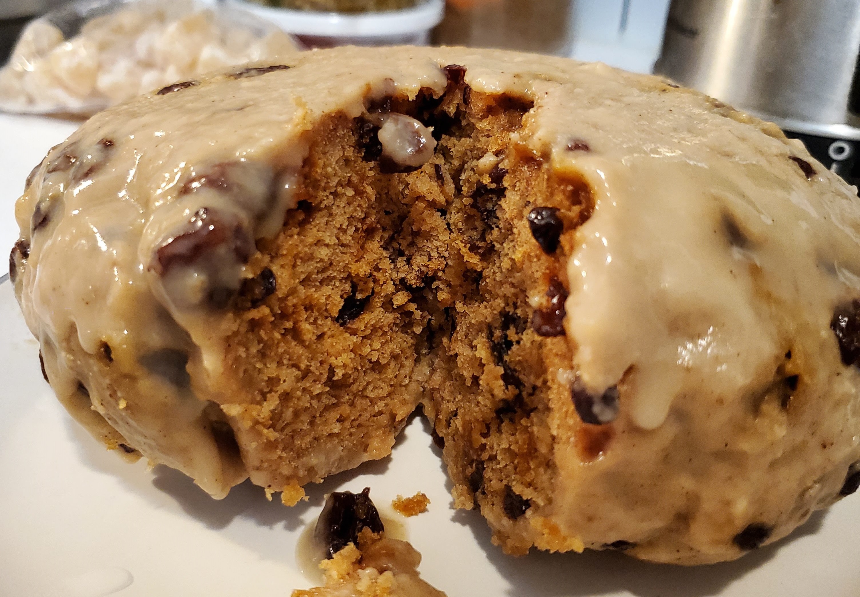 A close up photo of La Pouchine, a traditional Metis dish. This baked good is filled with raisins and covered with a sticky sweet topping