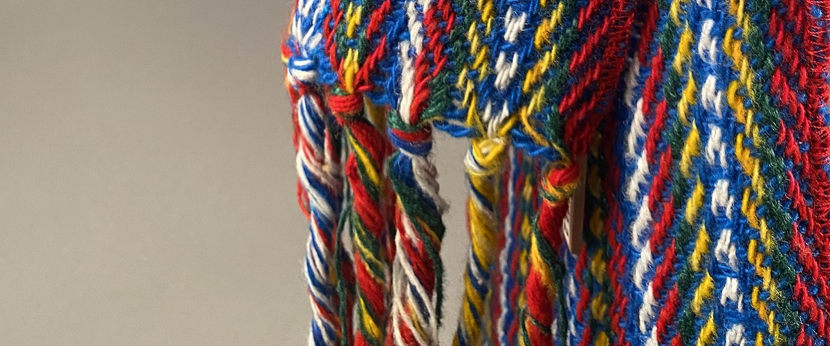 Detailed cropped image of the fringes of a colourful metis sash