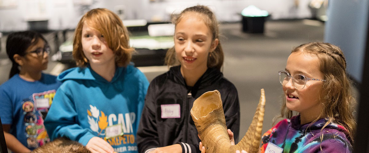 Three children learn about objects in the museum.