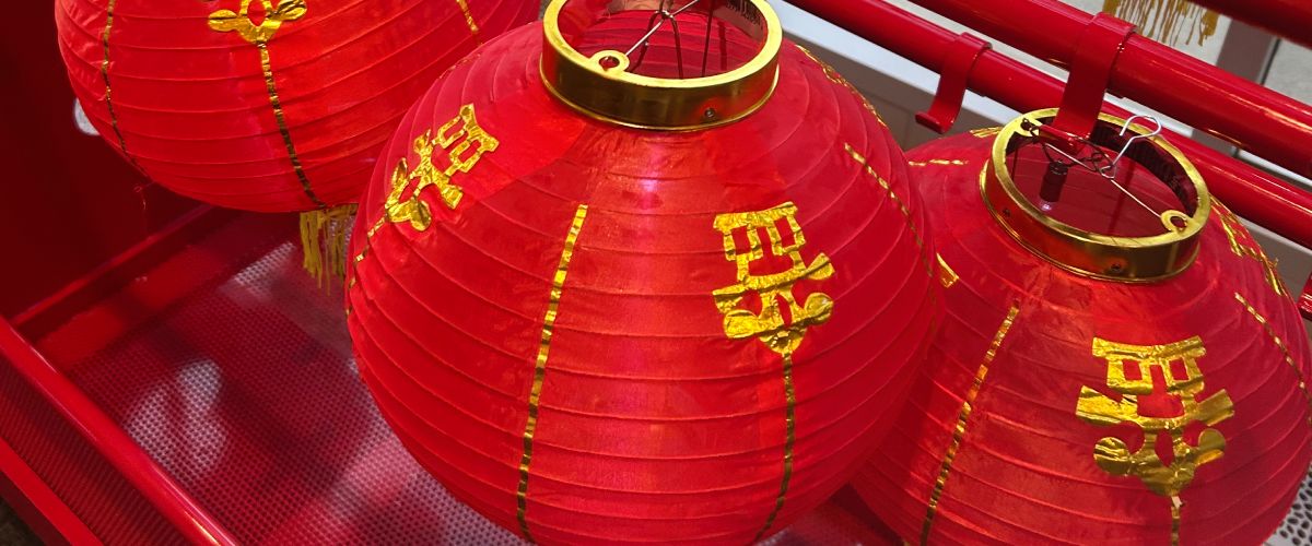Close up photo of red Chinese lanterns with gold characters