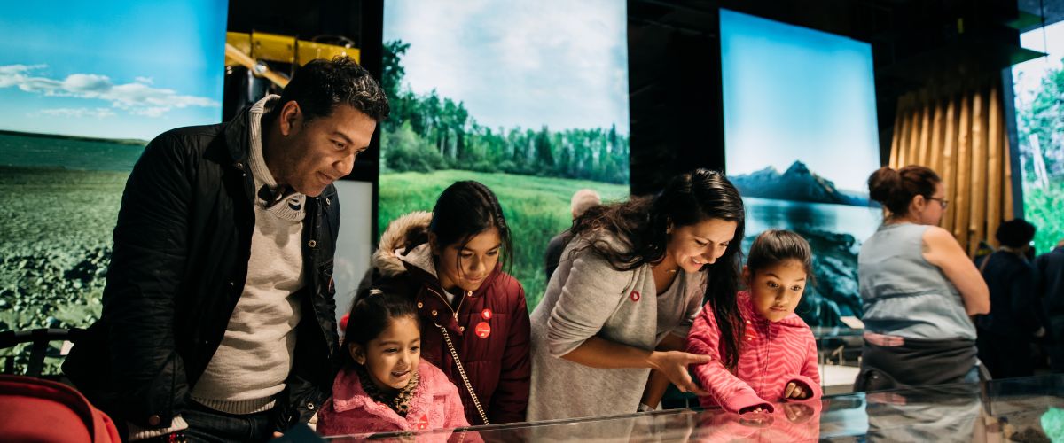 A family of four look into a display case in the Human History Hall.
