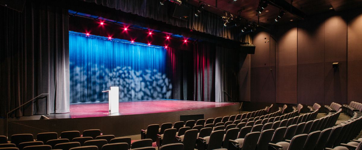 a photo of the theatre from behind the seats, looking toward the stage
