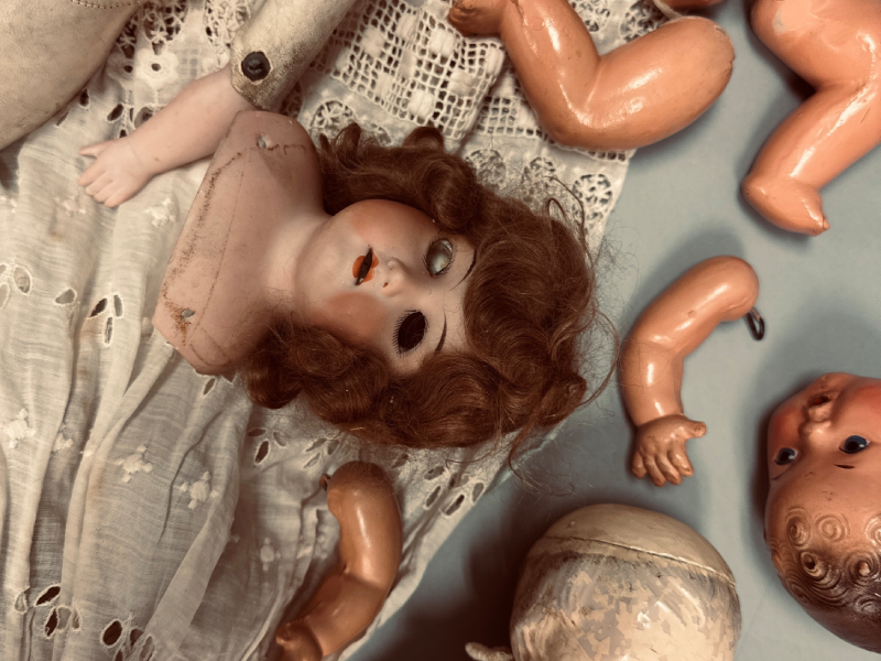 photo of several old, broken dolls