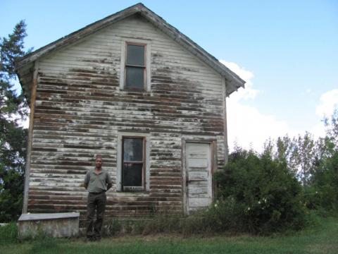 Paul stands in front of his grandparents’ two-storey house.