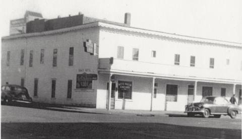 A black and white photo of a long, white building that once housed Hatti's Harlem Chicken Inn
