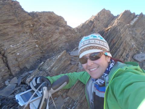 Dr. Corlett stands beside a rock formation.