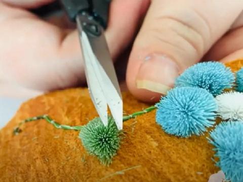 Sliver scissors trimming a small green tuft